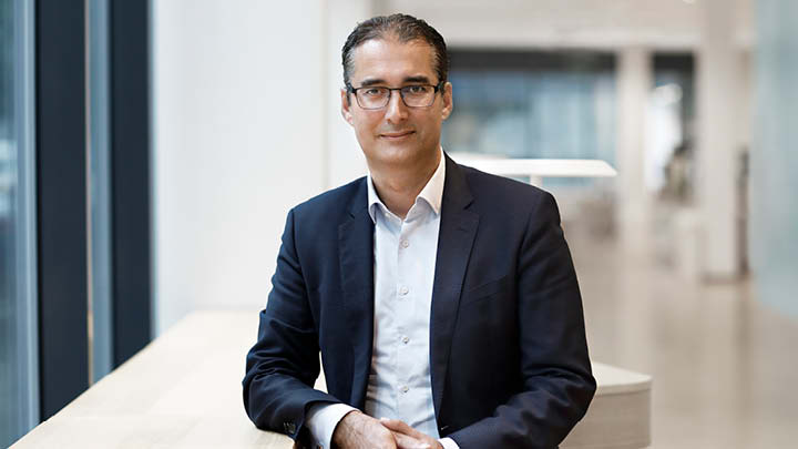 Bild på husfasad och Kurosh Beradari, marknads- och försäljningschef på Vattenfall Värme