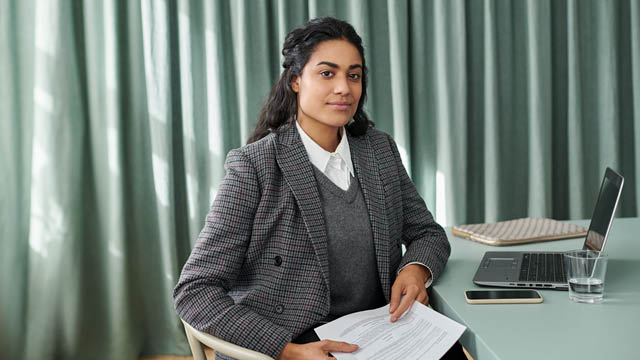 Kvinna som jobbar vid sitt skrivbord på ett kontor