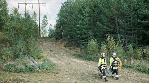 Två servicetekniker går längs en elnätsgata