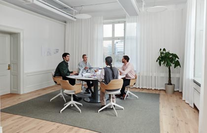 Fyra personer som sitter runt ett bord och diskuterar